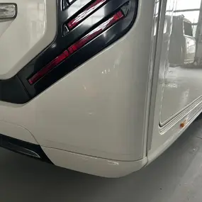 Heckansicht eines weißen Wohnmobils mit modernen LED-Rückleuchten in einer Halle.